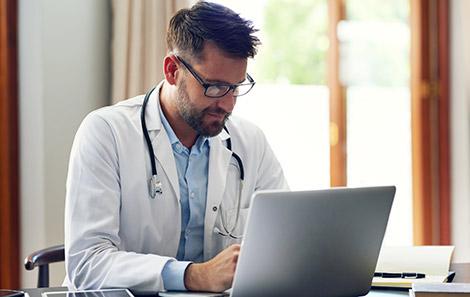 referring provider reads physician resource on his laptop